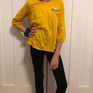 a yellow t-shirt “shine bright”